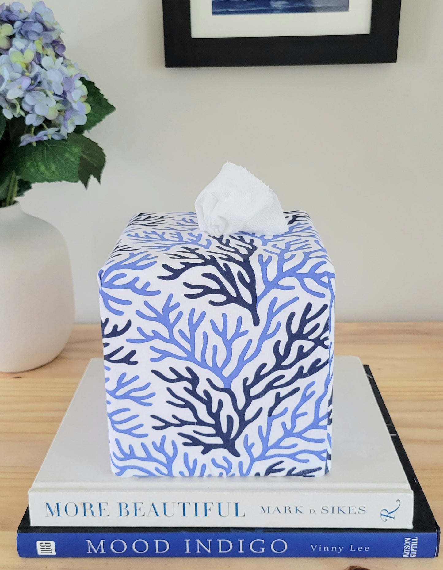 Cape Cod Coral AchooBox with blue coral pattern on a stack of books with a vase of flowers in the background