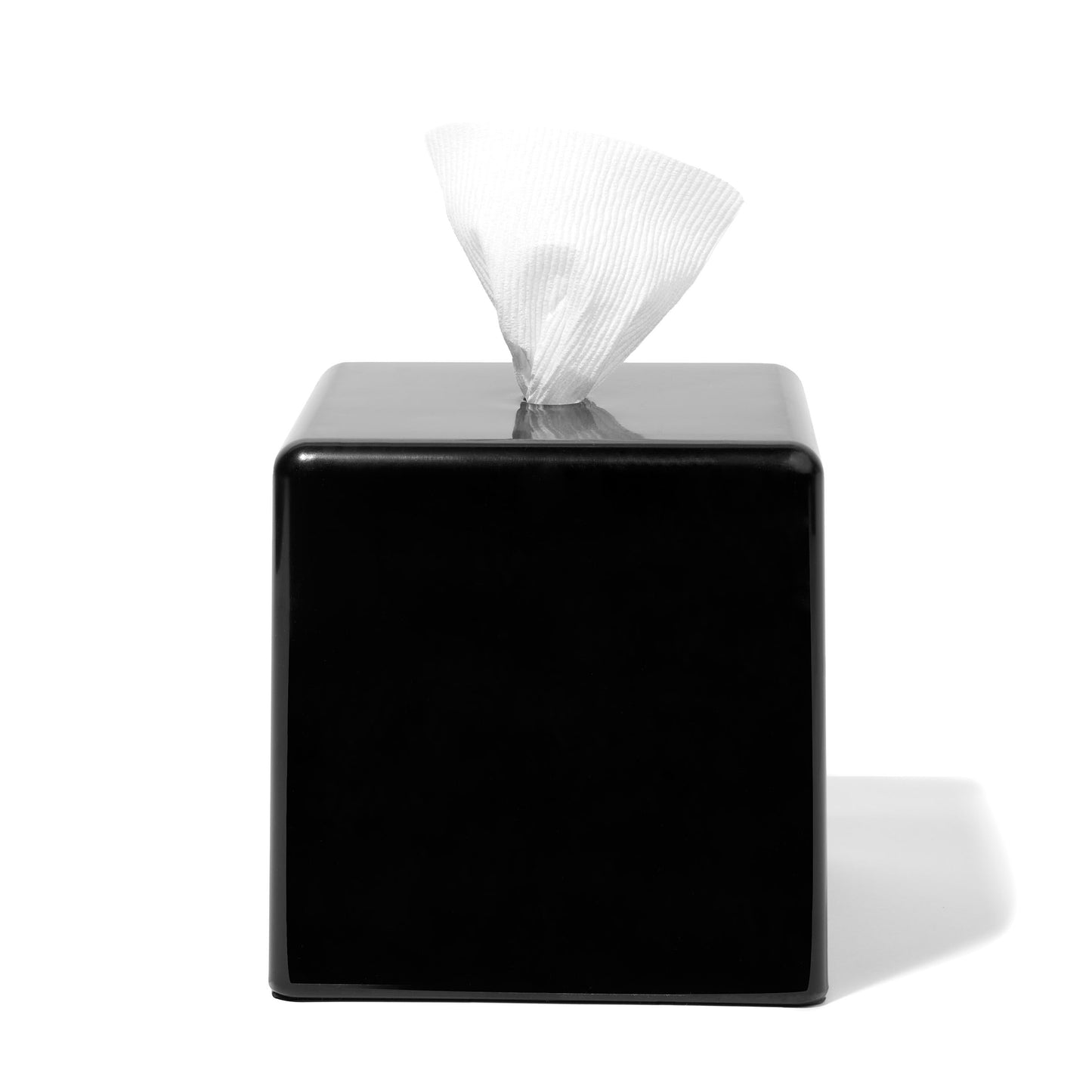 Black square tissue box with tissues peeking out on a white background