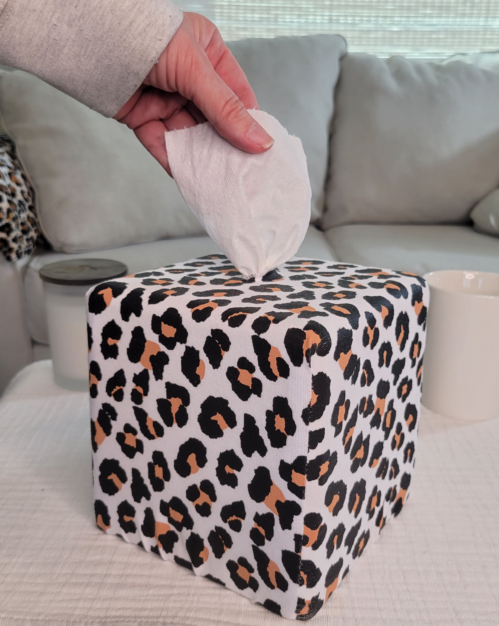 Modern Leopard AchooBox on coffee table with hand pulling tissue